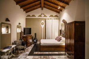 um quarto com uma cama, uma televisão e uma cadeira em Le Meraviglie di Alice em Cagliari
