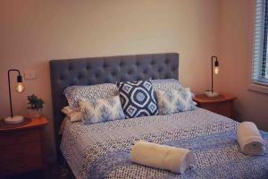 a bedroom with a bed with pillows and two lamps at Seafoam, Cowes, New Home, Fast NBN WIFI in Cowes