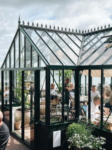 a group of people sitting in a glass greenhouse at Fanø Krogaard in Fanø
