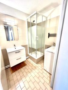 une salle de bain avec une douche en verre et un lavabo dans l'établissement Grand T2 proche de la mer, à Sète