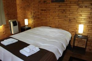 a bedroom with a white bed with two towels on it at Apart Dry Fly in Junín de los Andes