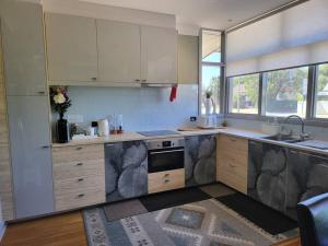 a kitchen with white cabinets and a stove top oven at Boutique style accomodation near Busselton Jetty in Busselton