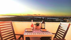 una mesa de madera con una botella de vino y una copa en Torralta Alvor Beach 601 en Alvor
