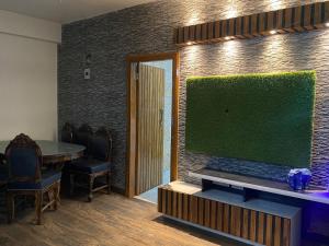 Fancy and Modern Apartment في باتنا: غرفة معيشة مع تلفزيون بشاشة مسطحة كبيرة على جدار