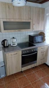 a kitchen with wooden cabinets and a stove top oven at Bungalow blühende Oase in Sebnitz