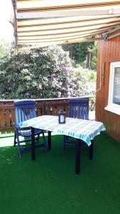 a table and two blue chairs on a patio at Bungalow blühende Oase in Sebnitz