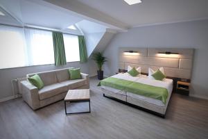 ein großes Schlafzimmer mit Bett und Sofa in der Unterkunft Hotel und Restaurant Kranichsberg in Woltersdorf + 39 Fotos