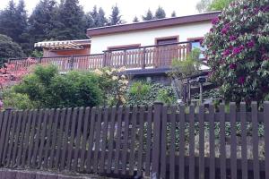 a fence in front of a house with flowers at Bungalow blühende Oase in Sebnitz