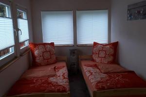 a small room with two beds and windows at Bungalow blühende Oase in Sebnitz