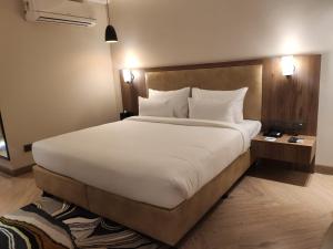 a large white bed in a hotel room at Udman Gurugram by Ferns N Petals, Sector 27, Golf Course Road in Gurgaon