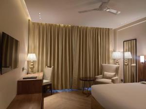 Habitación de hotel con cama, escritorio y silla en Udman Hotel Gurugram en Gurgaon