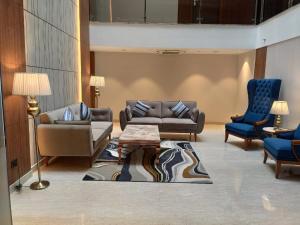 un soggiorno con divano, sedie e tavolo di Udman Hotel Gurugram a Gurgaon