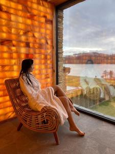 a woman sitting on a chair looking out a window at Czorsztyn Prestige in Czorsztyn