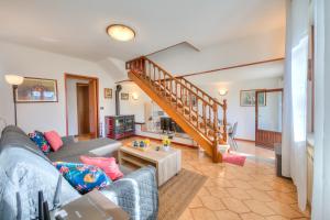 ein Wohnzimmer mit einem Sofa und einer Treppe in der Unterkunft Cedar House Villa Few Minutes From Lake - Happy Rentals in Angera