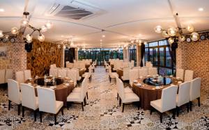 un salón de banquetes con mesas y sillas blancas en Haradise Suite Villa & Homestay Ha Long, en Ha Long