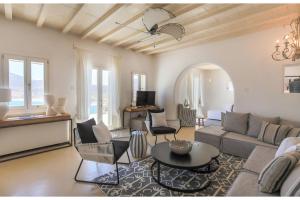 salon z kanapą i stołem w obiekcie Elite Mykonos Villa - Villa Roxane - Private Pool - 6 Bedrooms - Beachfront - Ftelia w mieście Dexamenes