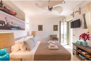 1 dormitorio con 1 cama grande y TV en Elite Mykonos Villa - Villa Roxane - Private Pool - 6 Bedrooms - Beachfront - Ftelia en Dexamenes