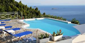 - une piscine avec des chaises et une vue sur l'océan dans l'établissement Secret Sporades Panoramic Residence, à Klíma