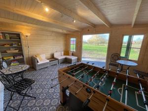 a room with a pool table in a cabin at Sage Shepherds Hut Boundary Farm Air Manage Suffolk in Woodbridge