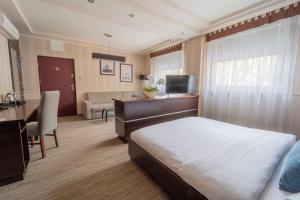 a bedroom with a bed and a desk and a room with a desk at Hotel Polski in Mielec