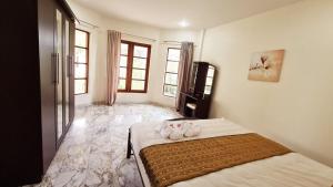 ein Schlafzimmer mit einem Bett mit Blumen darauf in der Unterkunft Schnes Bungalow mit gemeinschaftichem Auenpool und 2km vom Sandstrand enfernt in Ban Sa