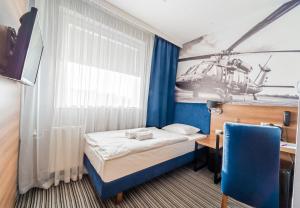 Pokój z łóżkiem, biurkiem i plakatem helikoptera w obiekcie Hotel Polski w Mielcu