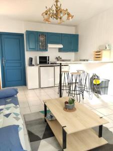 una cocina con armarios azules y una mesa en una habitación en Gîte de la Tride 1 avec terrasse proche du centre, en Lectoure