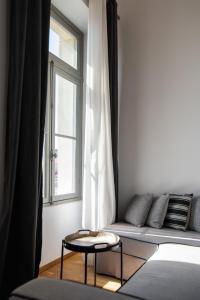 a living room with a couch and a window at Emporikon Athens Hotel in Athens