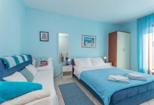 a blue bedroom with a bed and a couch at Savić Biograd in Biograd na Moru