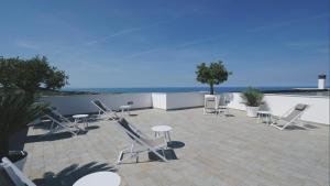 patio z krzesłami i stołami oraz oceanem w obiekcie Villa Verna Agriresort w mieście Francavilla al Mare