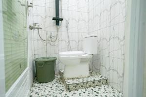 a bathroom with a toilet and a trash can at RedDoorz @ Seputih Jaya Lampung in Gunungsugih