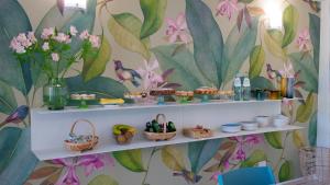 Villa Verna Agriresort في فرانكافيلا أل ماري: غرفة مع رفوف مع طعام وزهور على الحائط