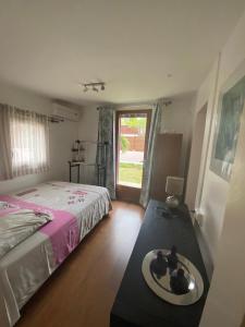 1 dormitorio con cama, mesa y ventana en Bungalow de charme, en La Saline-Les-Bains