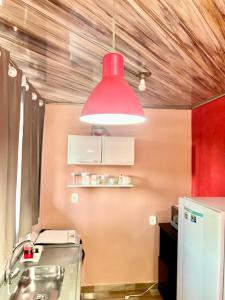 une lampe suspendue rouge suspendue au-dessus d'une cuisine dans l'établissement Aeroporto House, à Macapá