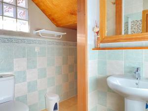 een badkamer met een wastafel, een toilet en een spiegel bij El Busque Casa Rural in Casla