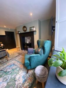 a living room with a blue chair and a fireplace at Clifton Georgian Townhouse, Inviting Ensuite Room & Plant Based Breakfast in Bristol