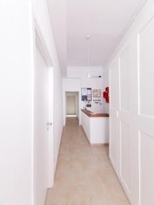 a hallway with white walls and a long hallway with a kitchen at Cielo Vaticano Guest House in Rome