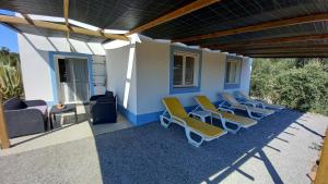 a patio with lounge chairs and a house at Monte Horizonte - Private Villas - Eco & Nature in Santiago do Cacém