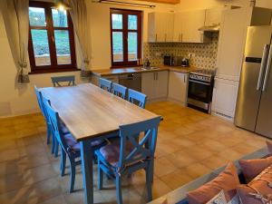 cocina con mesa de madera y sillas azules en Chata GOLDENBACH, en Malá Morava