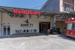 una tienda de puertas rojas con motocicletas estacionadas fuera de ella en RedDoorz Syariah At Jalan Raflesia Nusa Indah Bengkulu, en Bengkulu