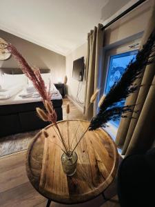 Habitación con una mesa de madera con plumas. en Hotel Garni BALTICpetite en Heringsdorf