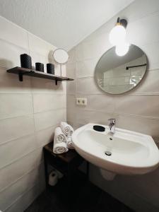 a bathroom with a sink and a mirror and towels at Hotel Garni BALTICpetite in Heringsdorf