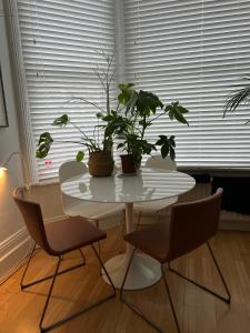 a white table with plants on it in a room at Gorgeous 1 bed flat near Richmond Bridge. in Richmond