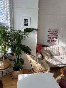 a living room with a couch and some plants at Gorgeous 1 bed flat near Richmond Bridge. in Richmond