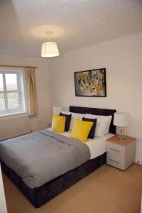 - une chambre avec un grand lit et des oreillers jaunes dans l'établissement Charming 3 Bed House in Bristol, à Bristol
