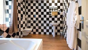 a bathroom with a black and white checkered wall at Ault - Villa Aultia Hotel - baie de somme in Ault