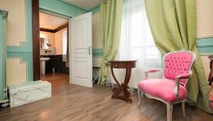 een woonkamer met een roze stoel en een raam bij Ault - Villa Aultia Hotel - baie de somme in Ault