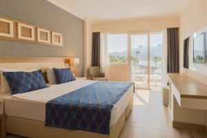 Habitación de hotel con cama y balcón en Fortezza Beach Resort, en Hisarönü