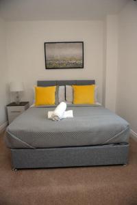 a bedroom with a bed with yellow and white pillows at Spacious 3 Bed House in Bristol in Bristol