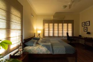 a bedroom with a bed and a window and a desk at Luho 187 in Bangalore